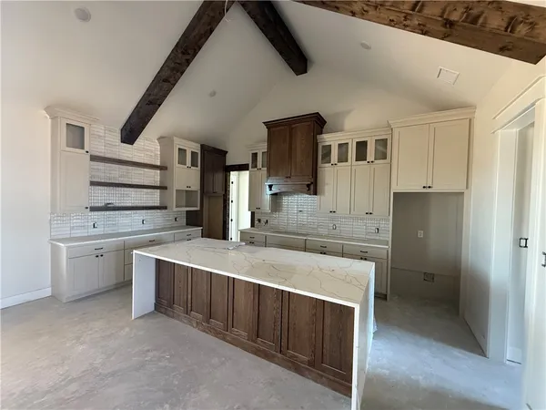 a large white kitchen with a stove and a sink