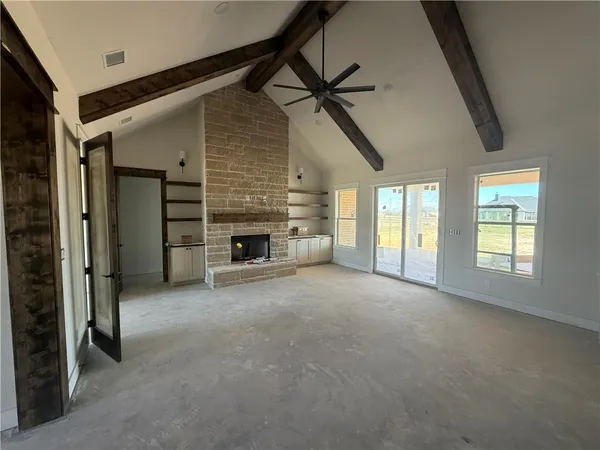 a view of empty room with fireplace and windows