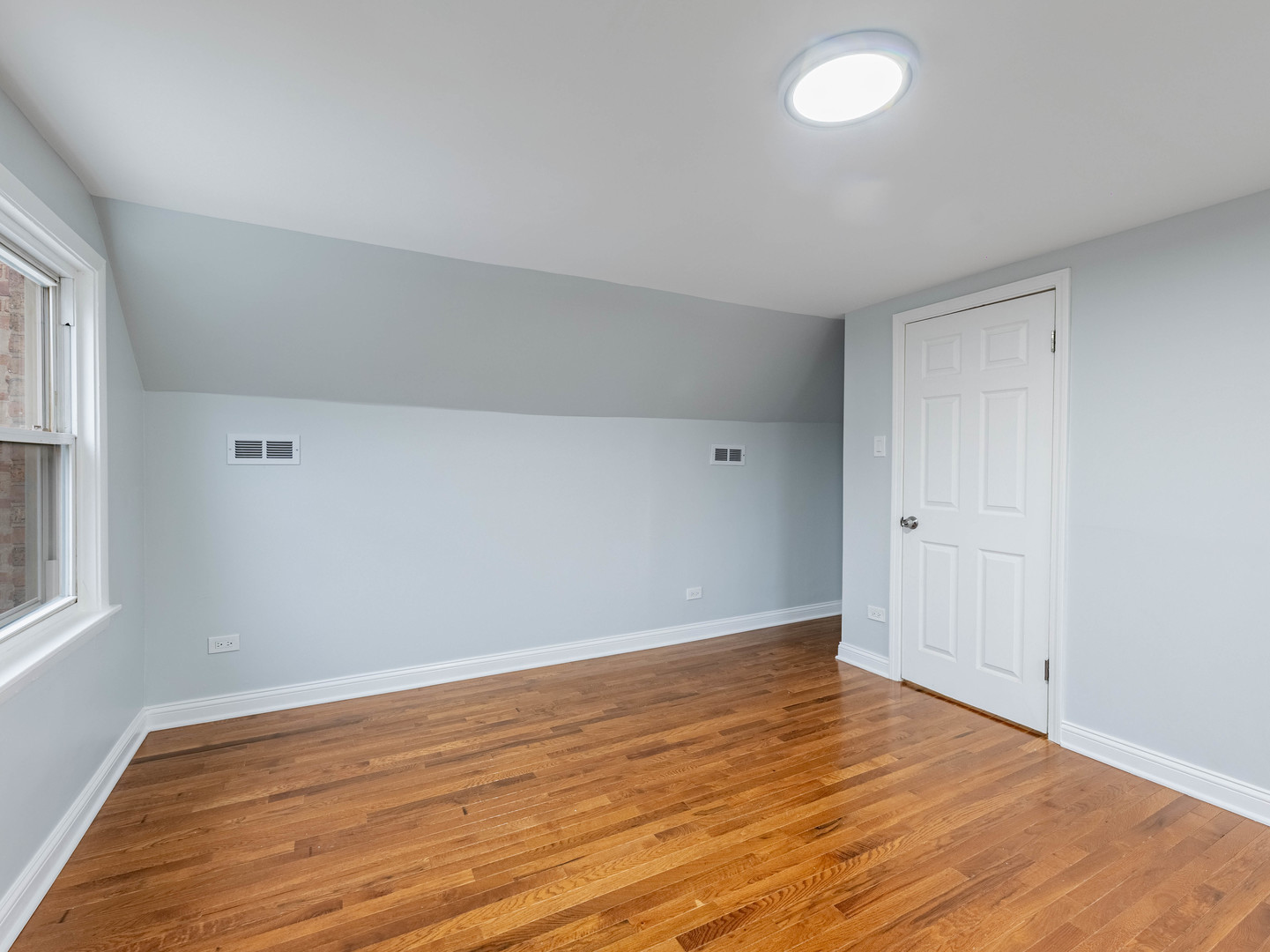 7028 South Honore Street Chicago, IL 60636 - Photo 15 of 18 an empty room with wooden floor and windows