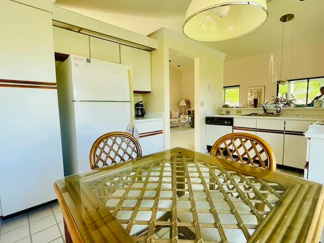 a living room with a table chairs and a refrigerator