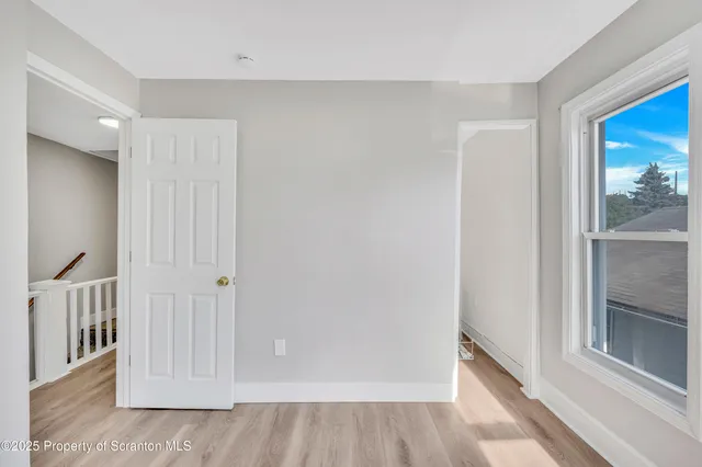 a view of a hallway with wooden floor and entryway