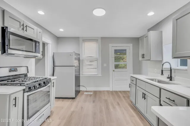 a kitchen with stainless steel appliances granite countertop a refrigerator stove and sink