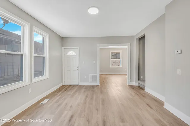 wooden floor in an empty room with a window