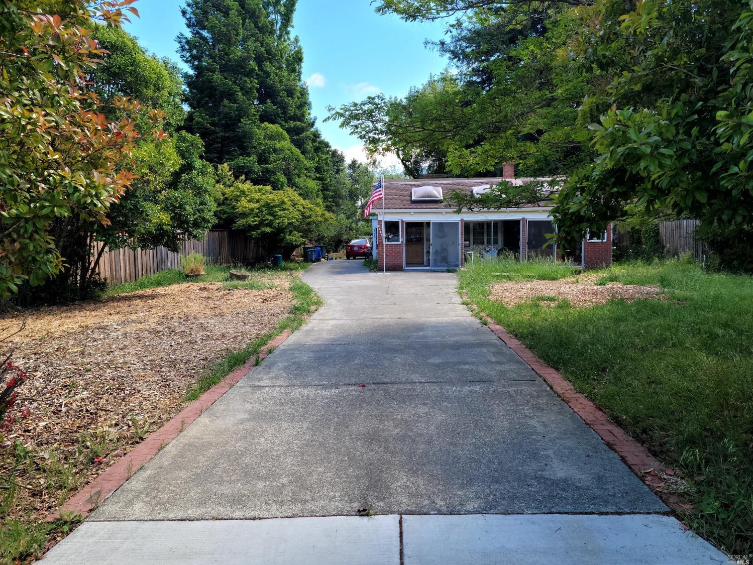 a front view of a house with a yard and trees