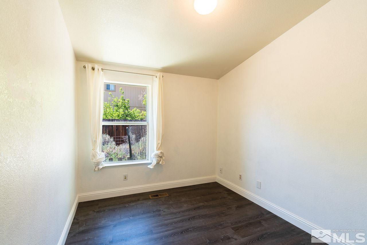 6542 Fall River Circle Reno, NV 89523 - Photo 12 of 17 an empty room with wooden floor and a window