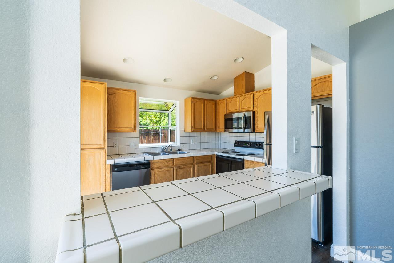 6542 Fall River Circle Reno, NV 89523 - Photo 5 of 17 a large kitchen with a stove a sink dishwasher and a refrigerator