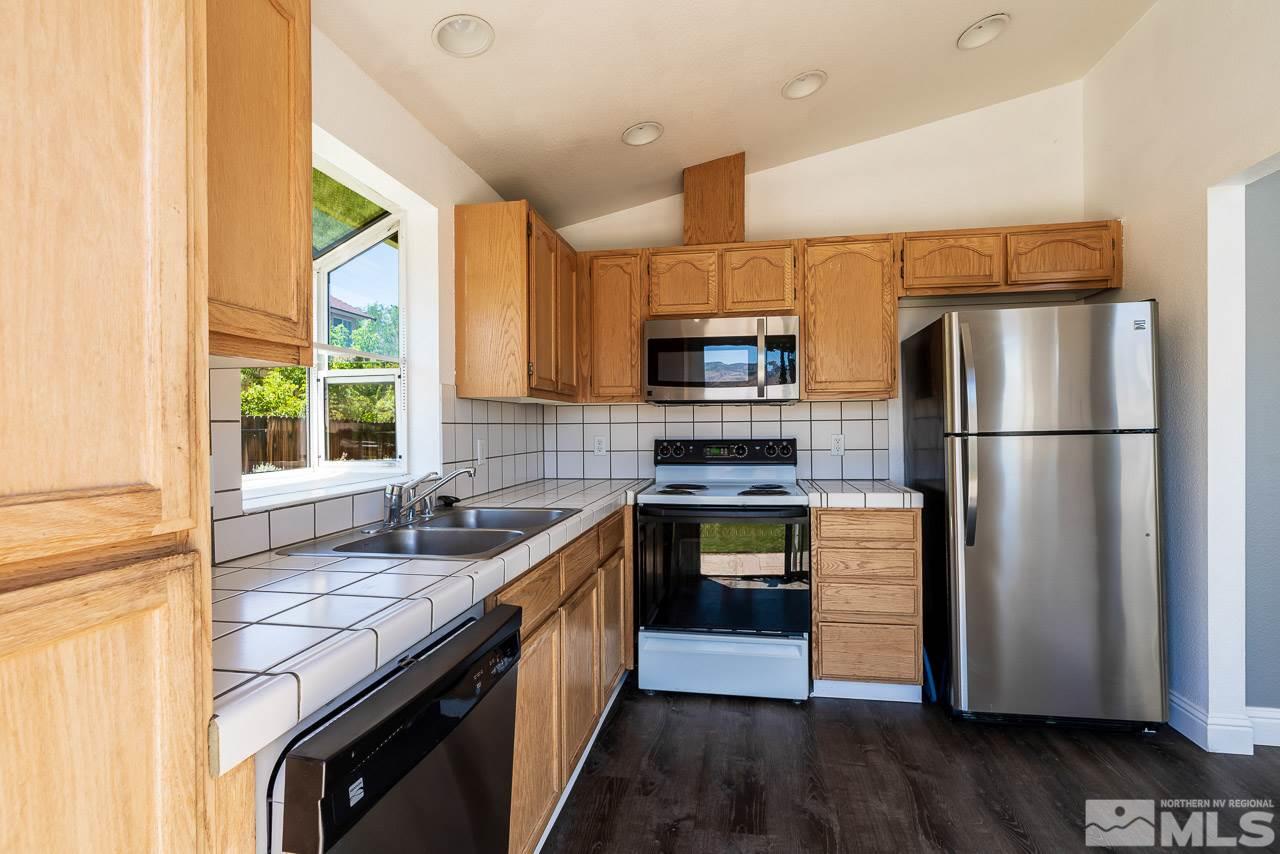 6542 Fall River Circle Reno, NV 89523 - Photo 6 of 17 a kitchen with kitchen island granite countertop a sink appliances cabinets and a counter top space