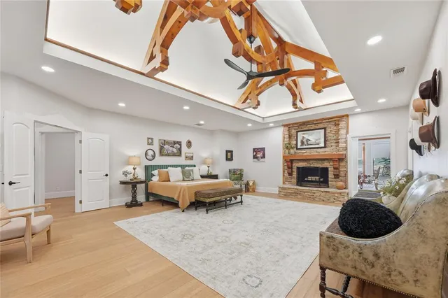 a spacious bedroom with a bed a mirror and dresser