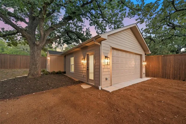 a view of a house with a big yard and large trees