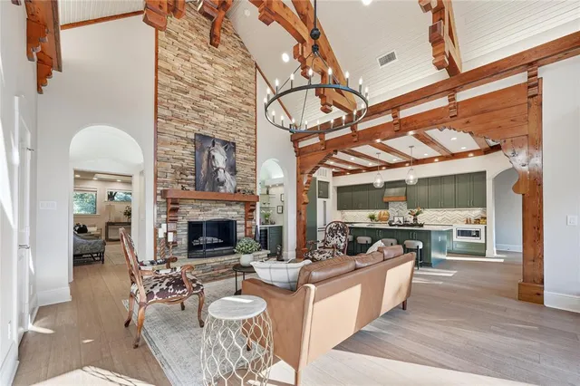 a living room with furniture a fireplace a flat screen tv and kitchen view