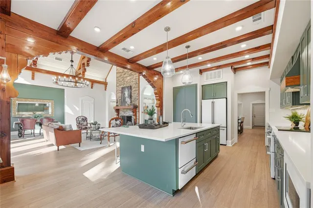a large white kitchen with a large window and stainless steel appliances