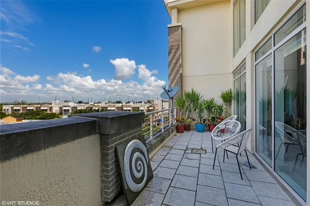 a view of a patio with couches and a table and chairs with wooden floor and city view