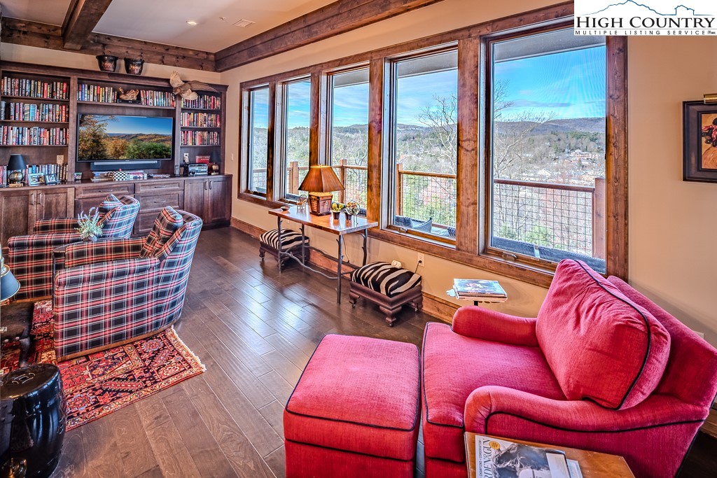 215 Cone Vista Circle, Unit B Blowing Rock, NC 28605 - Photo 13 of 50 a living room with furniture a flat screen tv and floor to ceiling window