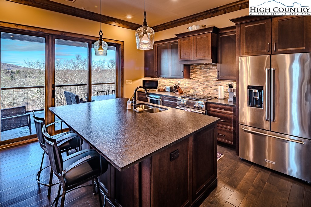 215 Cone Vista Circle, Unit B Blowing Rock, NC 28605 - Photo 26 of 50 a kitchen with kitchen island a table chairs stove and refrigerator