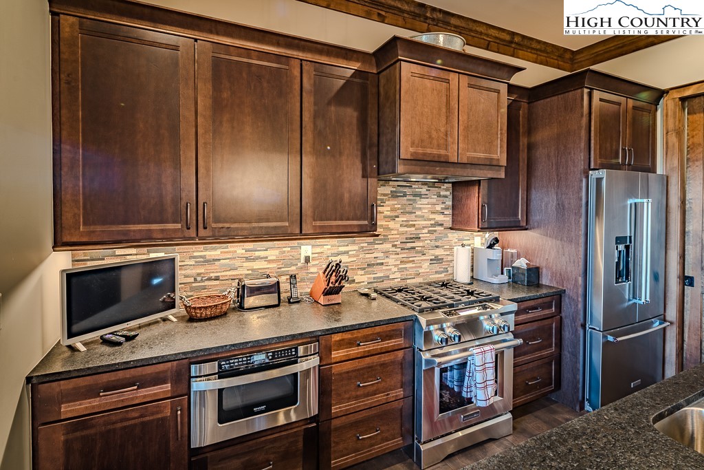 215 Cone Vista Circle, Unit B Blowing Rock, NC 28605 - Photo 27 of 50 a kitchen with stainless steel appliances granite countertop a stove and a refrigerator