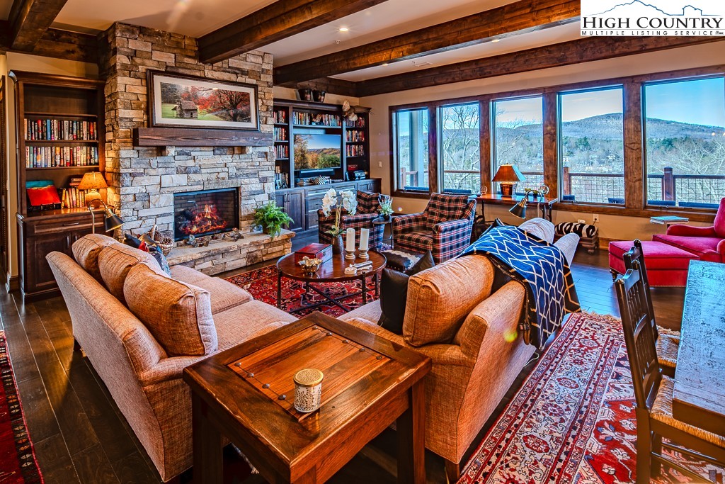 215 Cone Vista Circle, Unit B Blowing Rock, NC 28605 - Photo 5 of 50 a living room with furniture a fireplace and a floor to ceiling window