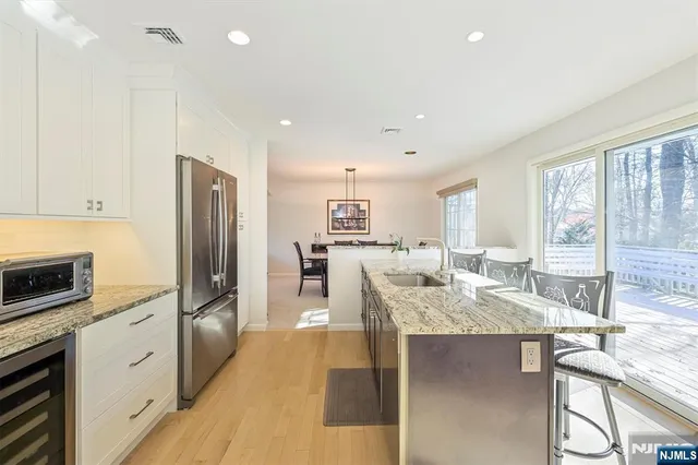 a kitchen with granite countertop white cabinets and stainless steel appliances