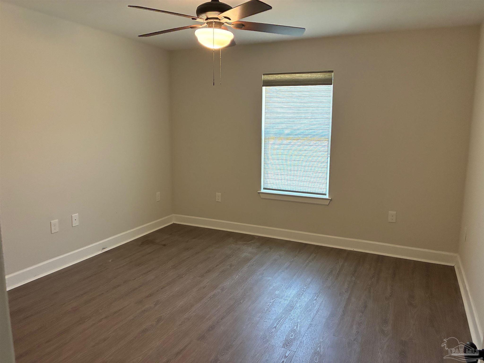 4090 Manchester Court Pace, FL 32571 - Photo 18 of 33 an empty room with wooden floor fan and windows