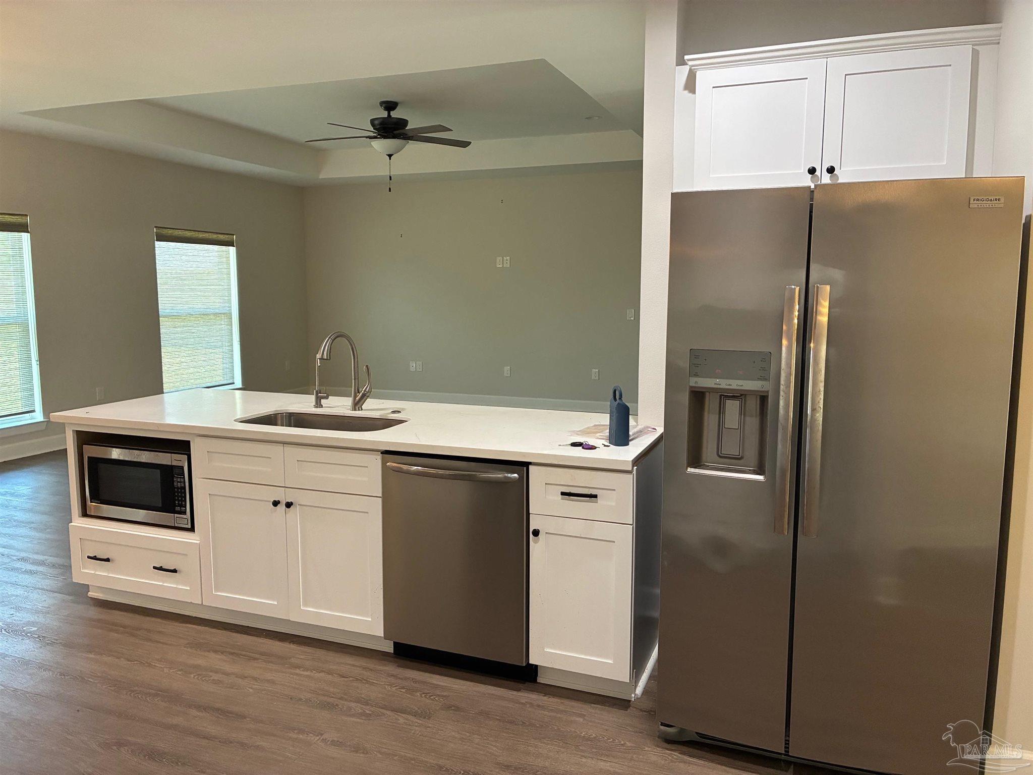 4090 Manchester Court Pace, FL 32571 - Photo 6 of 33 a kitchen with a refrigerator sink and cabinets