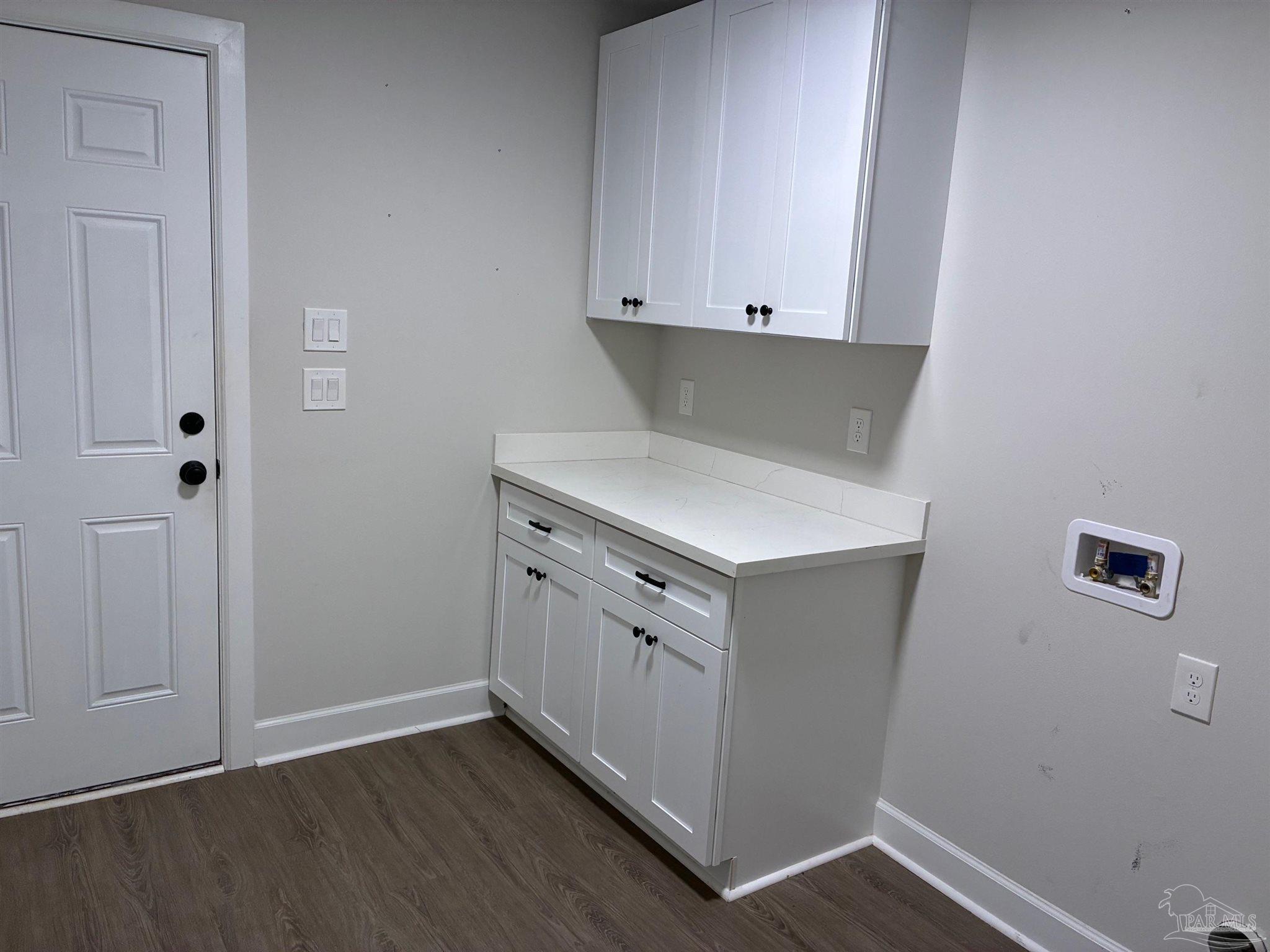 4090 Manchester Court Pace, FL 32571 - Photo 10 of 33 a kitchen with white cabinets and a wooden floor