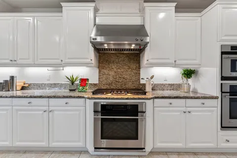 a kitchen with granite countertop a stove sink and cabinets