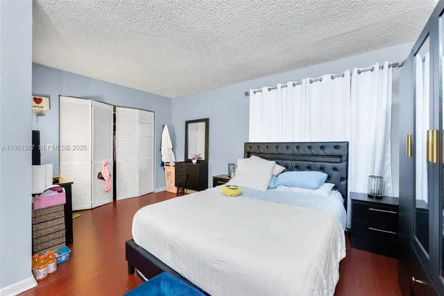 a bedroom with a bed dresser and a large mirror