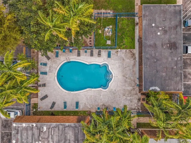 view of a wooden door with a bench and potted plants