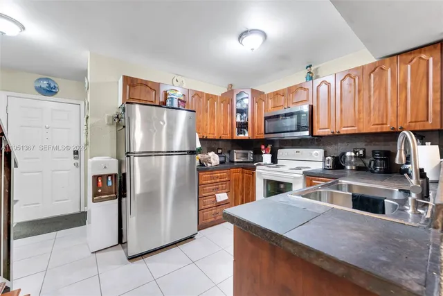 a kitchen with stainless steel appliances granite countertop a refrigerator a stove a sink and a refrigerator