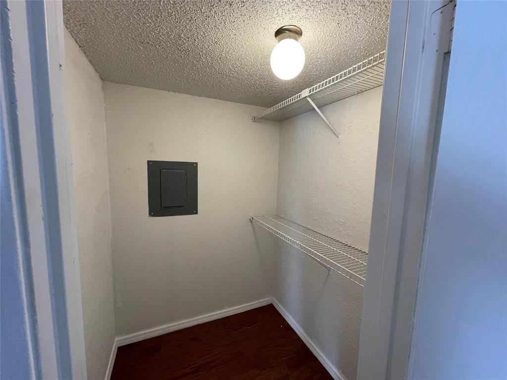 9811 Walnut Street, Unit F207 Dallas, TX 75243 - Photo 7 of 12 Walk in closet with electric panel and dark wood finished floors