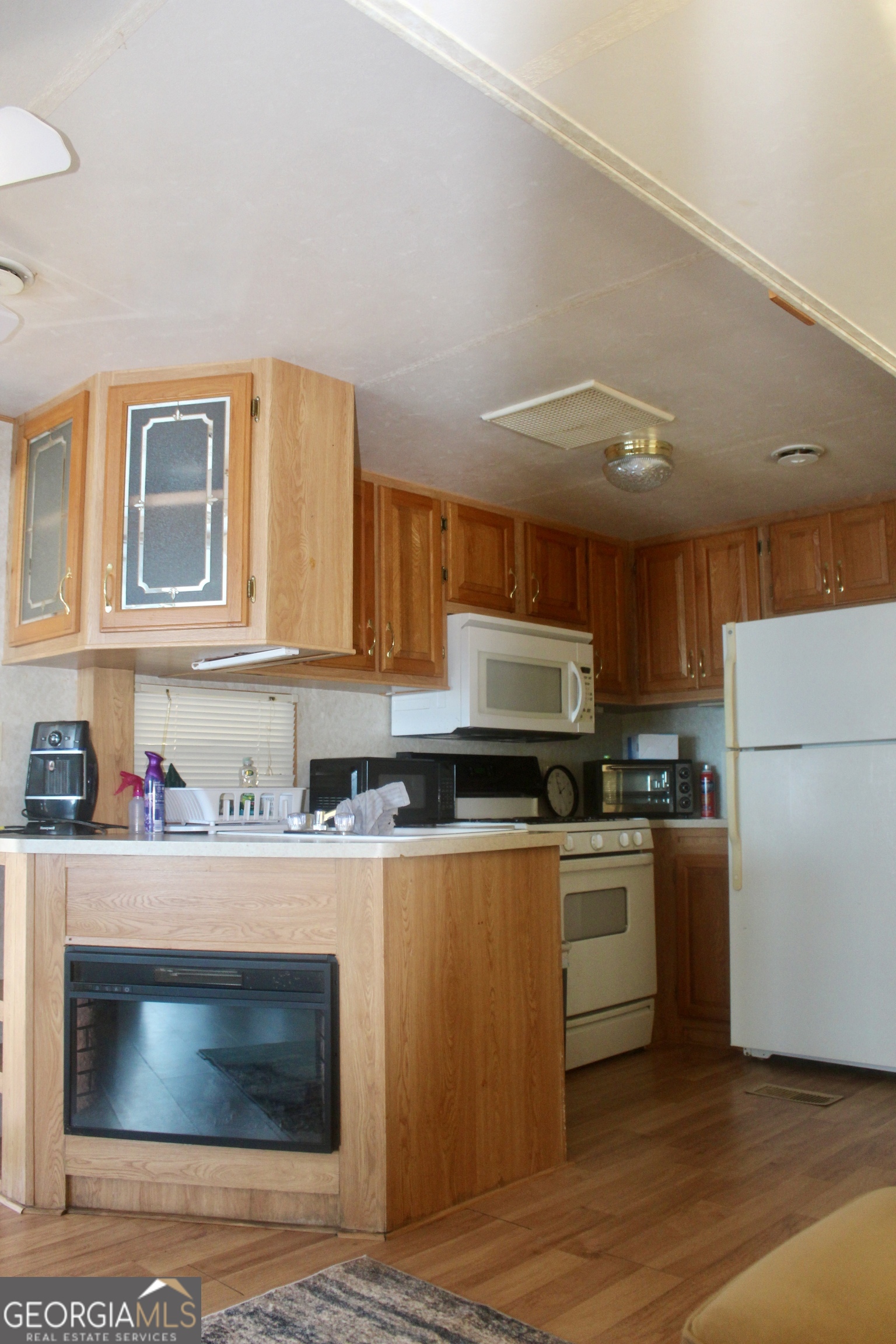 183 Holiday Loop Cleveland, GA 30528 - Photo 9 of 22 a kitchen with stainless steel appliances granite countertop a stove top oven a sink dishwasher and a refrigerator with wooden floor