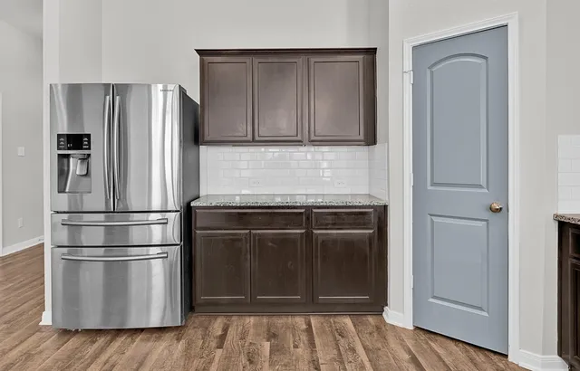 a kitchen with granite countertop stainless steel appliances and wooden floor