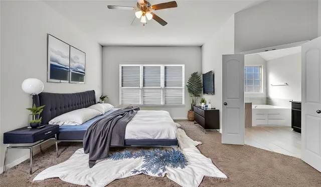 a bedroom with a large bed and a chandelier
