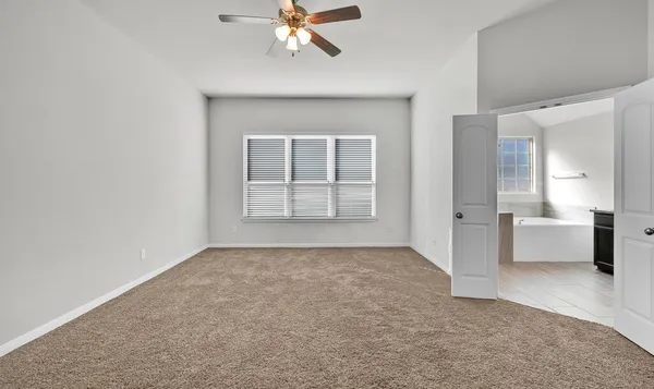 an empty room with windows and cabinet