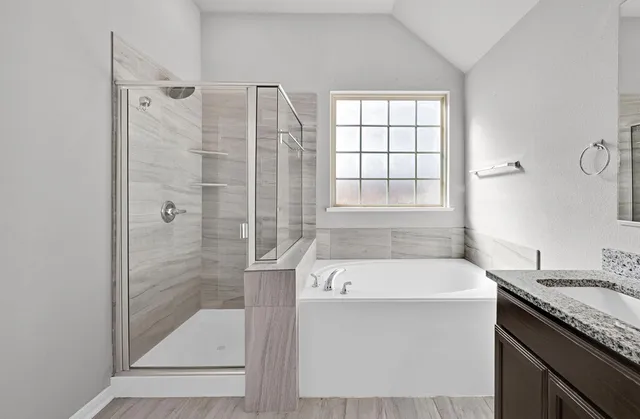 a bathroom with a granite countertop sink a shower and a bathtub