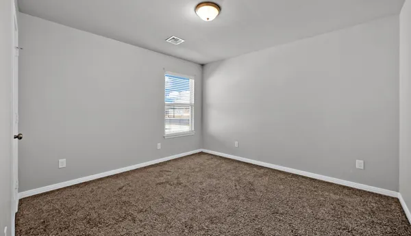 a bedroom with a large bed and a flat tv screen on dresser
