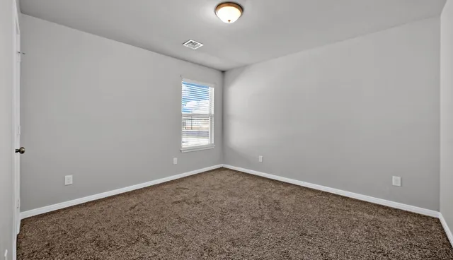 a bedroom with a large bed and a flat tv screen on dresser