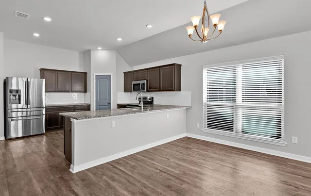 a view of a kitchen with a sink wooden floor and a refrigerator