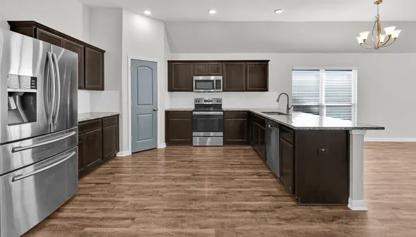 a large kitchen with stainless steel appliances kitchen island granite countertop a stove and refrigerator