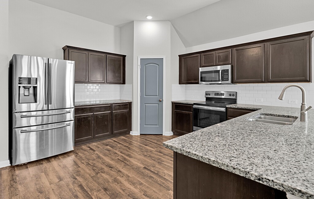 10624 Langham Drive Waco, TX 76708 - Photo 10 of 40 a kitchen with stainless steel appliances kitchen island granite countertop a refrigerator and a stove top oven