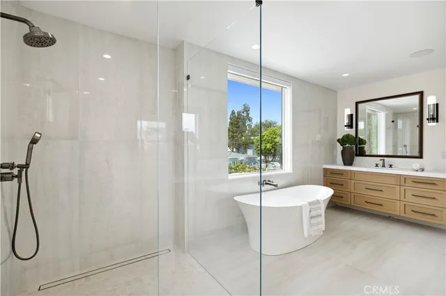 a large bathroom with a double vanity sink a large mirror and a bathtub