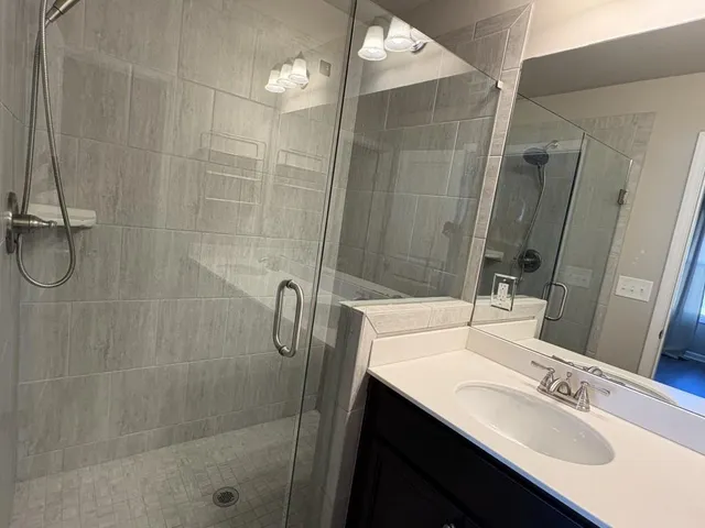 a bathroom with a shower sink and mirror
