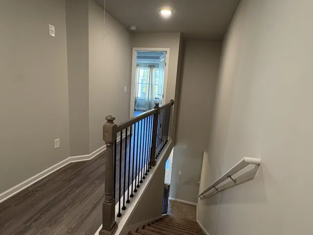 a view of a hallway with wooden floor and entryway