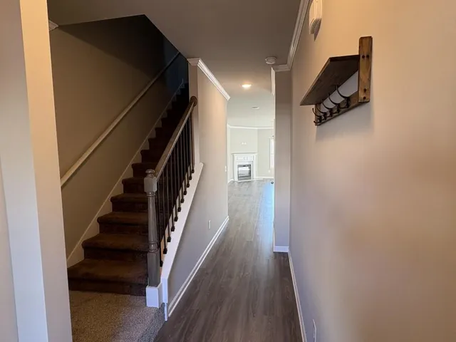 a view of hallway with stairs and wooden floor