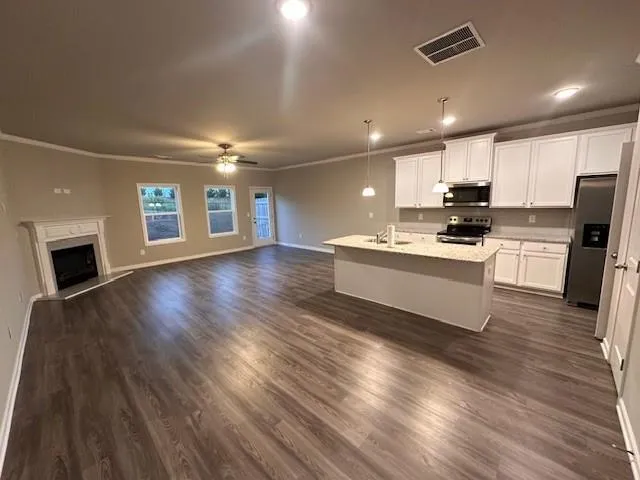 a kitchen with stainless steel appliances a stove top oven a sink dishwasher and a refrigerator