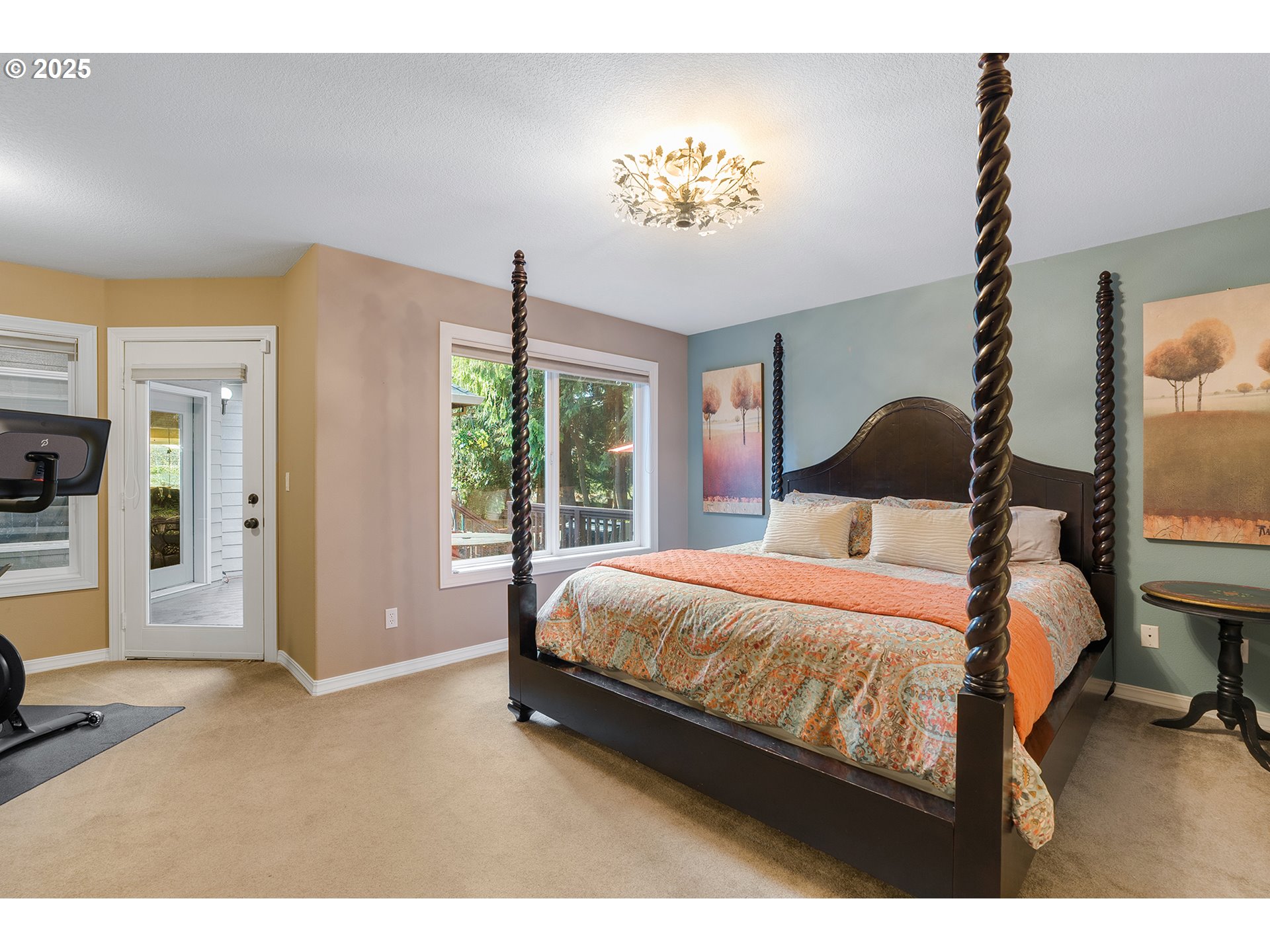 15943 Southwest Enna Court Portland, OR 97224 - Photo 21 of 48 a bedroom with a large bed and a chandelier