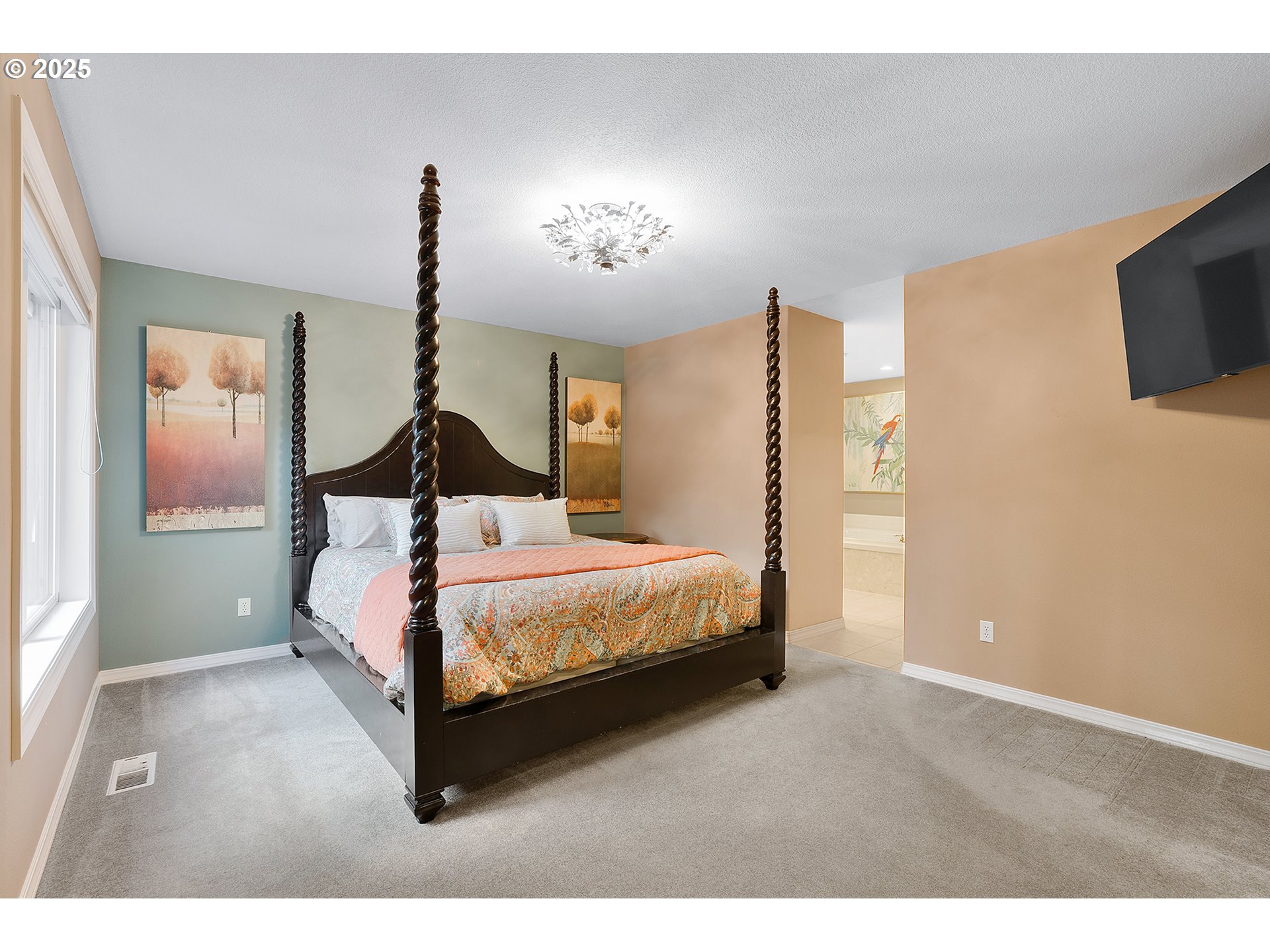 15943 Southwest Enna Court Portland, OR 97224 - Photo 24 of 48 a spacious bedroom with a bed and a flat screen tv