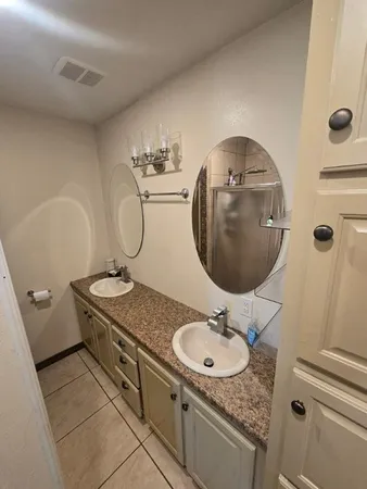 a bathroom with a granite countertop sink a mirror and shower