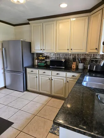 a kitchen with stainless steel appliances granite countertop a stove a sink and a refrigerator
