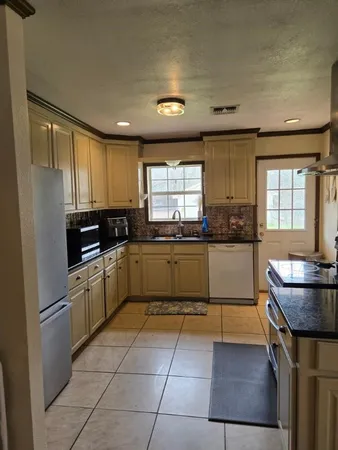 a kitchen with stainless steel appliances granite countertop a stove a sink and a refrigerator