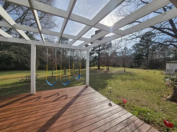 a view of a wooden deck with a yard